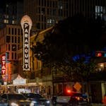 Bustling city street scene at Paramount Theater in Austin, TX during night.